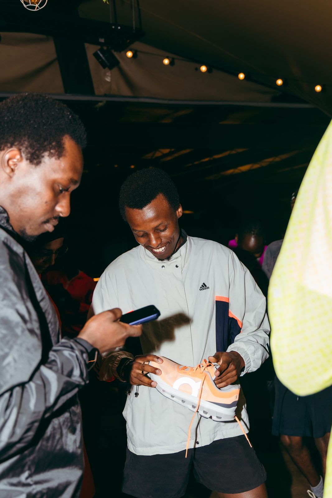 A runner shows off his On sneaker to a friend at an Open Lanes event
