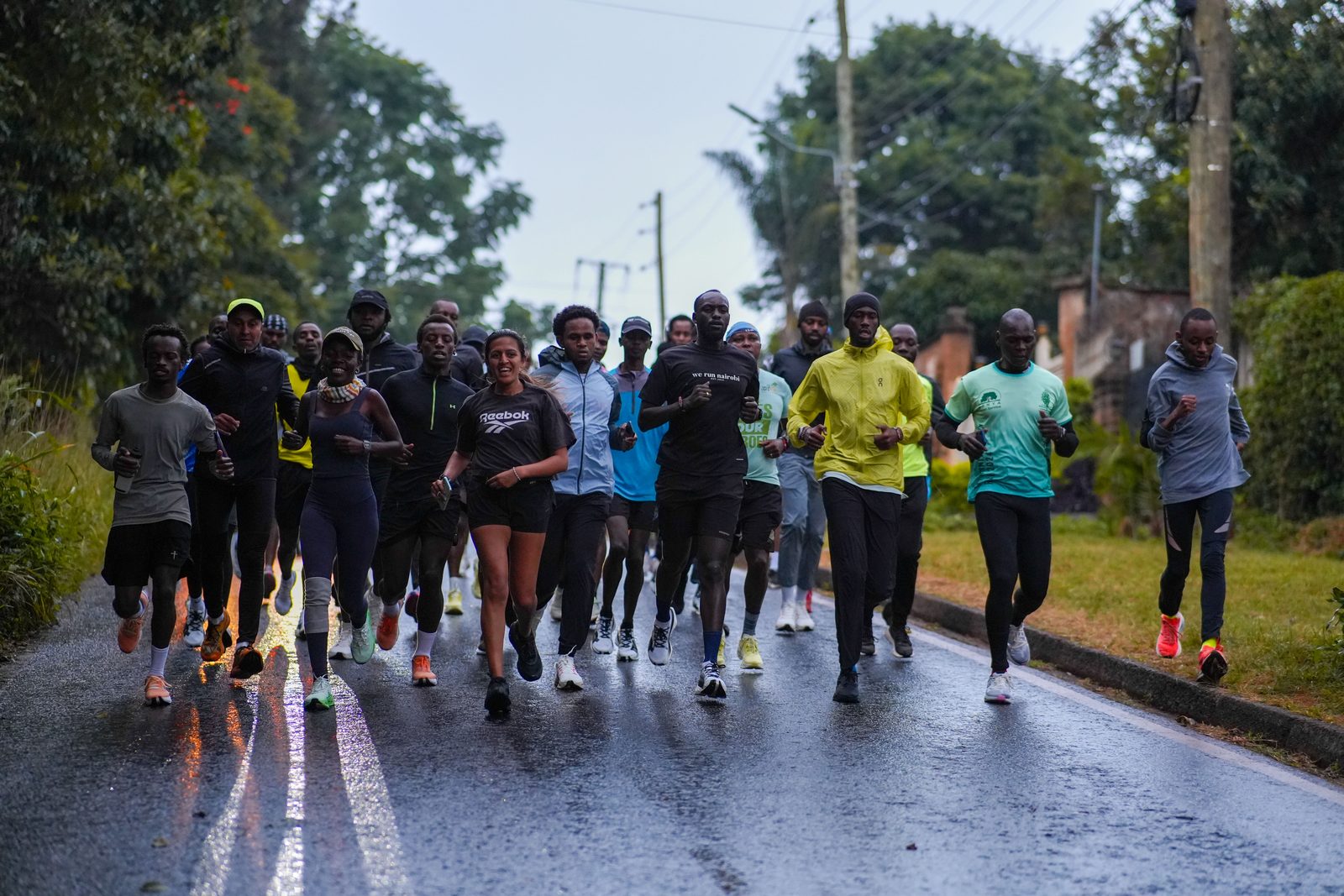 A pack of runners moving through Nairobi streets on a rainy morning run